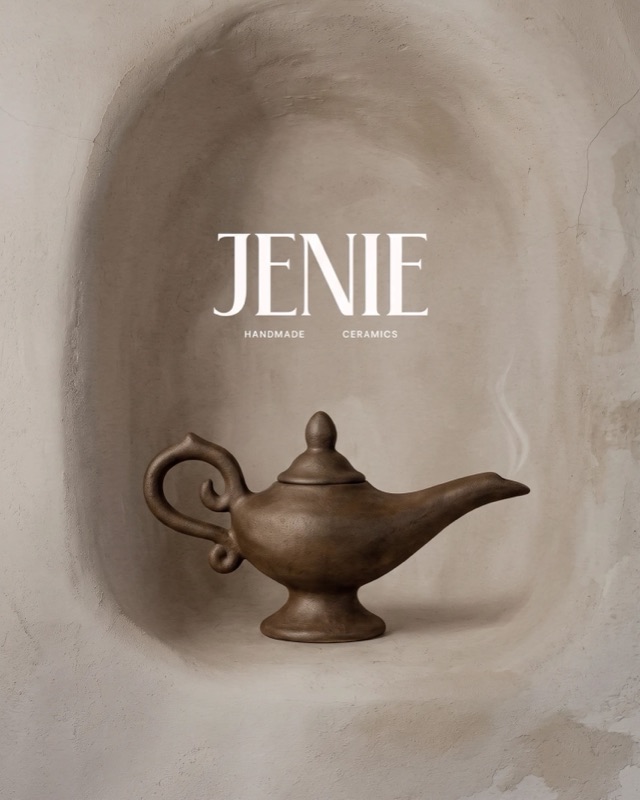 A dark ceramic oil lamp in a plaster alcove, captioned JENIE handmade ceramics.