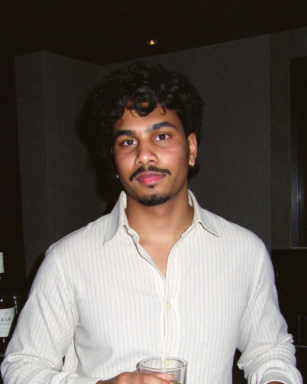 Nadil, co-founder, portrait at a bar