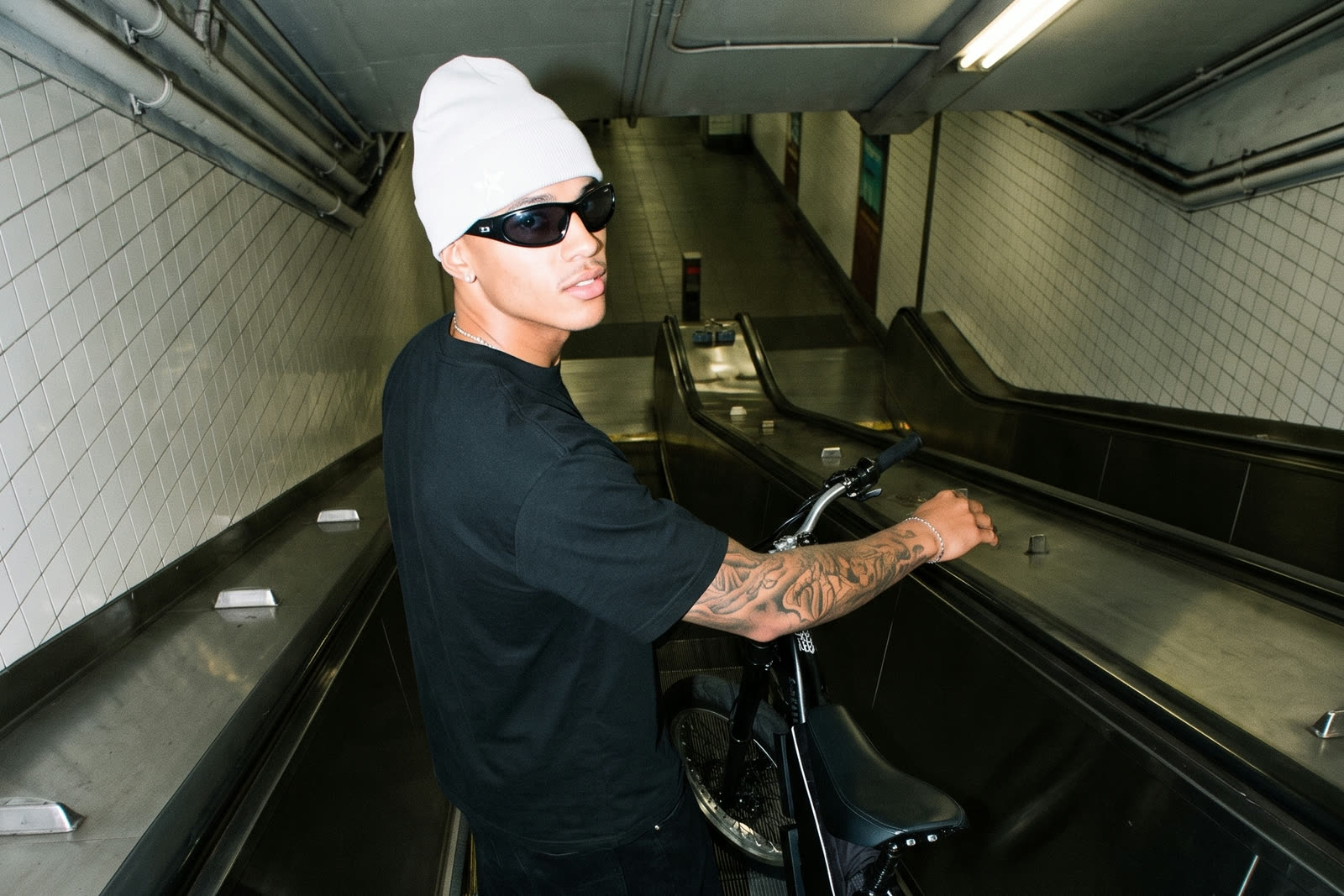 F1 Ebikes, rider with an F1 Ebikes bike on a station escalator