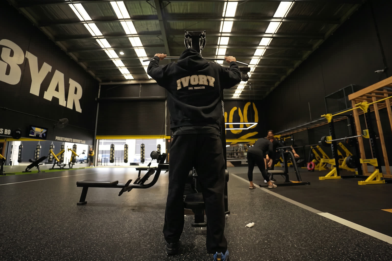 A member walking in through the entry gates of a warehouse gym